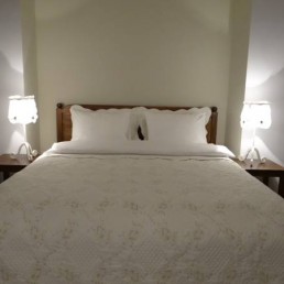 [:en]king size bed, pillows,lamps,tables,bed sheets, decoration,wooden bed, white wall[:]